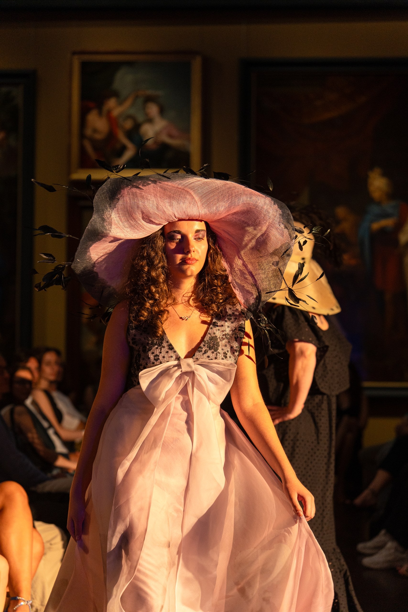 Création couture et capeline rose sur le podium