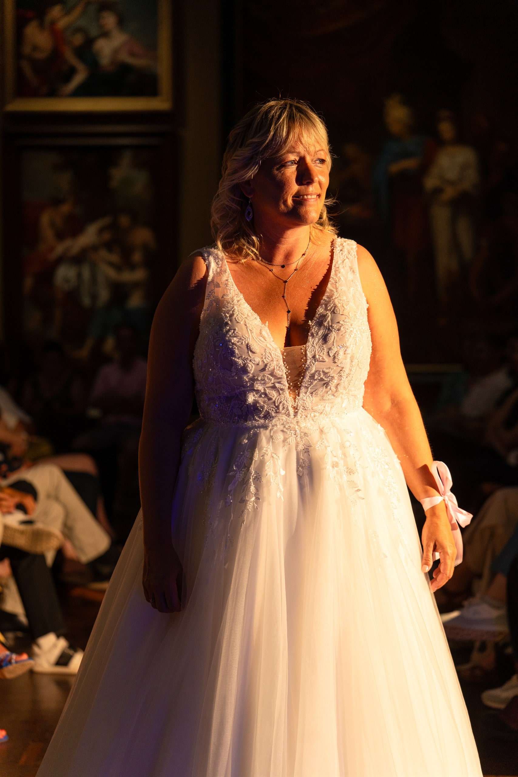 Mariée en dentelle devant les œuvres