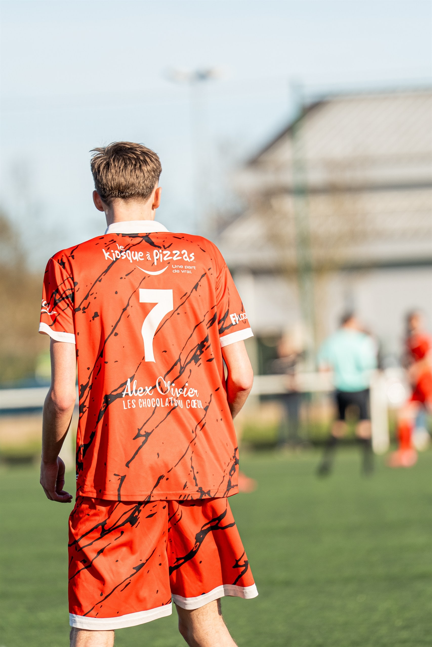 Milieu de terrain de dos, maillot orange numéro 7