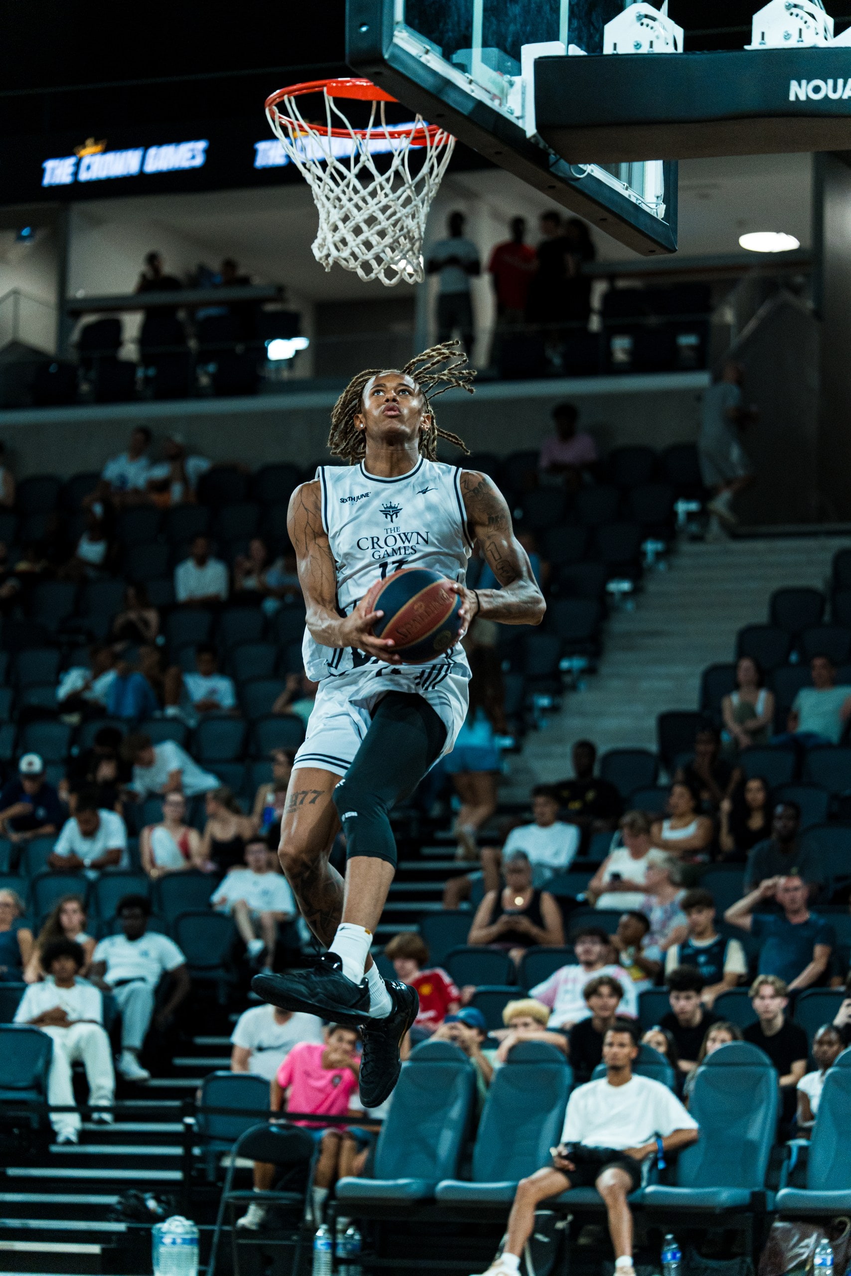 Dribble lancé vers le cercle, tribunes en fond