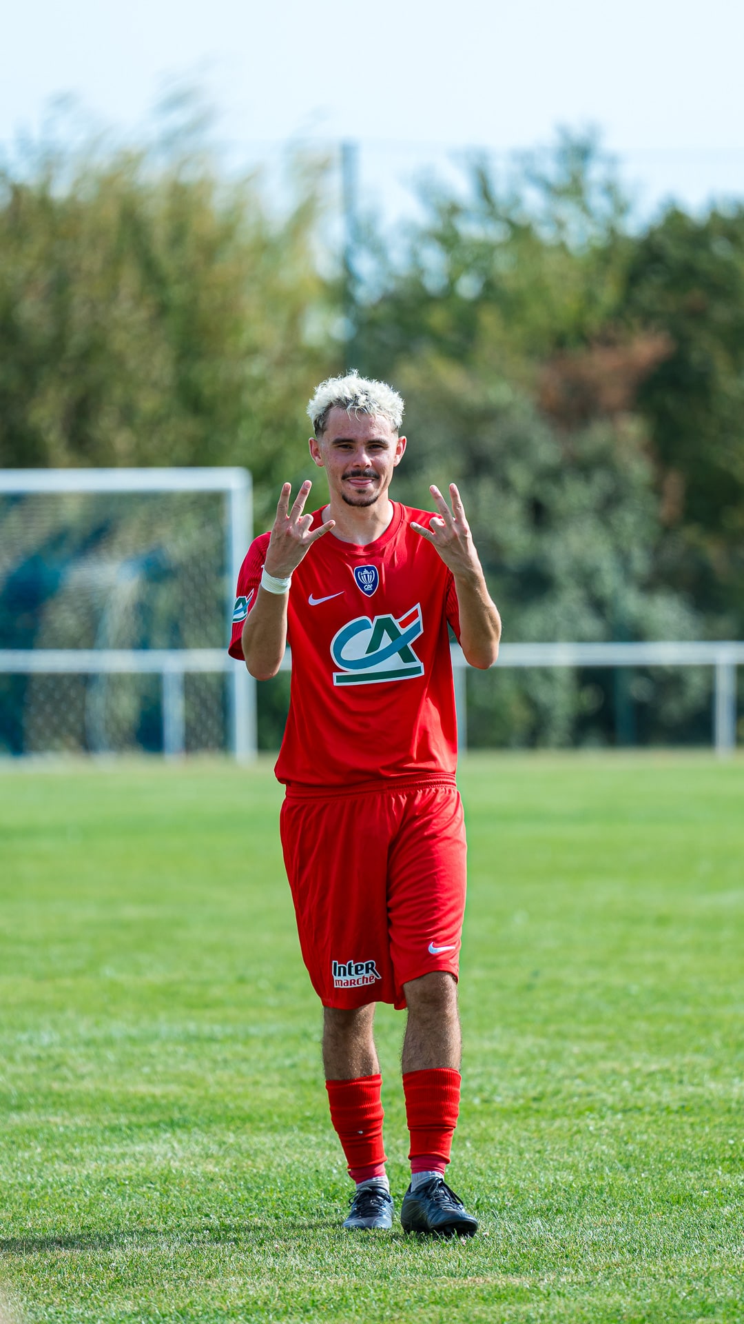Joueur en rouge saluant le public en Coupe de France
