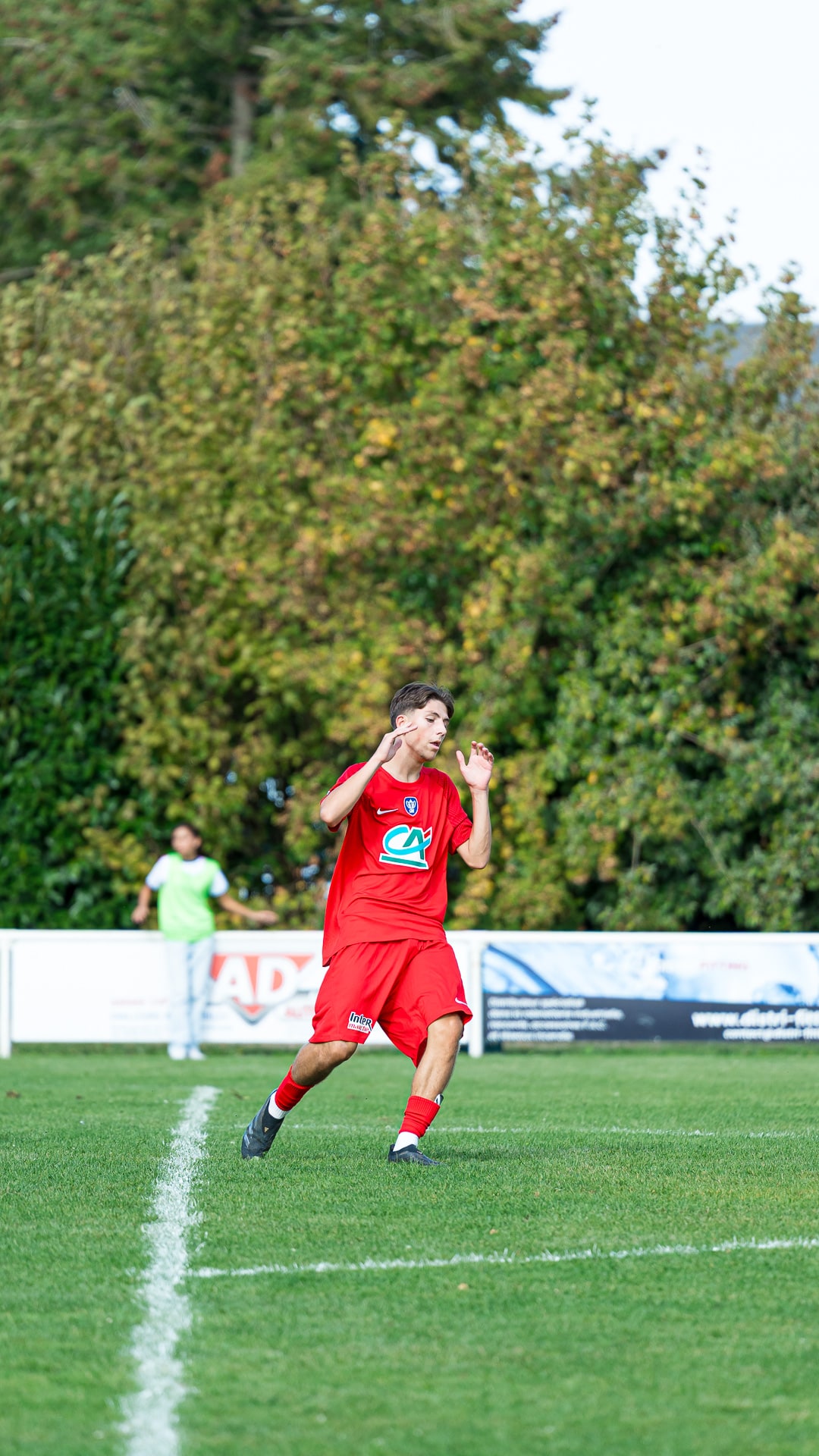 Footballeur en rouge sur la pelouse